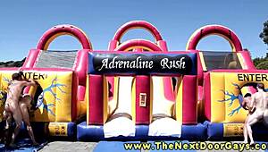 Muscular hunks blow each other outdoors.