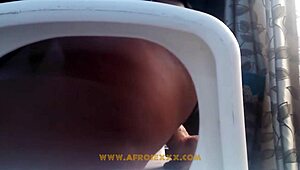 African woman in mini skirt pleasures herself on chair