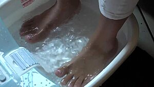 Asian woman enjoys messy barefoot foot bath
