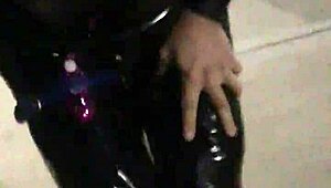 cd in latex walks outdoors with vibrator attached