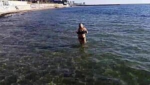 Milf plays with her big tits and ass on public beach