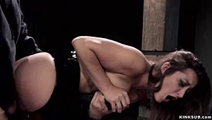 Latex-clad busty woman restrained and penetrated in bondage