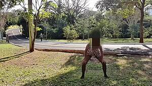 A Brazilian woman dances in the street, watched by her husband and a stranger