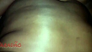 Busty black woman gives blowjob to big black cock in blowbang