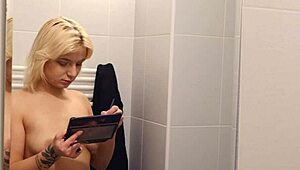Blonde naked girl feels exposed while applying makeup