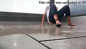 Masked babe jerks off wildly on wet balcony