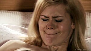 Blonde pornstar Delphine fingers her small tits while masturbating