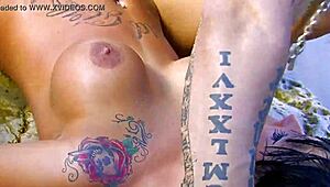 Muscular man has sex with tattooed woman with implants at the beach.