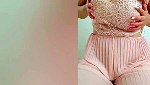 The young cutie in a pink dress, DepravedMinx, starts playing with her big tits solo in front of the camera