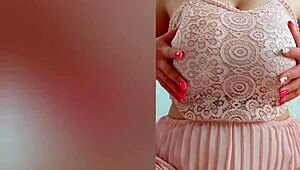 The young cutie in a pink dress, DepravedMinx, starts playing with her big tits solo in front of the camera
