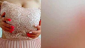 The young cutie in a pink dress, DepravedMinx, starts playing with her big tits solo in front of the camera