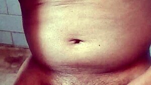 Old Indian gay bottom enjoys his own golden shower casually. He bends over for the flow.