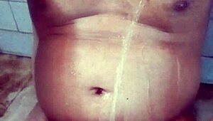 Old Indian gay bottom enjoys his own golden shower casually. He bends over for the flow.