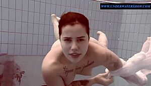 Tattoed Sara, a brunette teen, swims in the sea