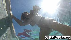 Olivia strips down for steamy solo fun in the pool. Her blonde curves shine under the summer sun.