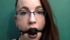 dark lipstick BALLGAG DROOLING with intense eye contact in close-up.