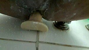 In the shower, he pleasures himself with a dildo