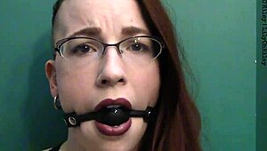 dark lipstick BALLGAG DROOLING with intense eye contact in close-up.