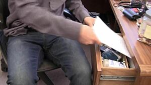 Alisha Adams, a busty redhead, in an office scene