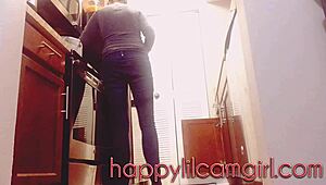 The girl ignores the guy while cleaning the kitchen