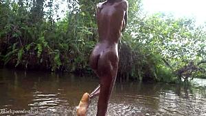 African girl bathes in river