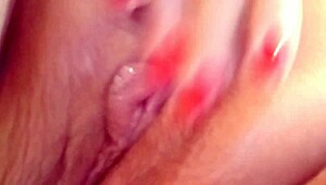 The prostitute masturbates her pink wet pussy