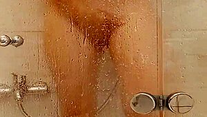 She caresses herself in the bath with big tits and ass