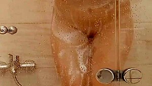 She caresses herself in the bath with big tits and ass