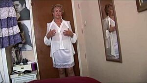 Naughty blonde granny flashes pussy under skirt in see-through top and slip