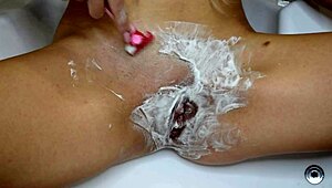 Close-up pov of shaving an unshaven pussy in the bathroom.