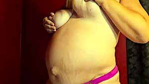 The pregnant wife is wet and ready to strip, ripping off her clothes and thong.