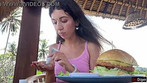 Cute girl feels excited eating burger with cum on face in public cafe