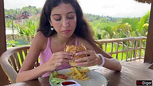 Cute girl feels excited eating burger with cum on face in public cafe