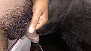 Indian stud pisses hot stream in bathroom stroking massive black cock to orgasm