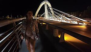Luscious milf struts braless pantyless on bridge