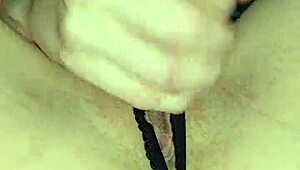 Glove-wearing milf milks cock with wet pierced nipples