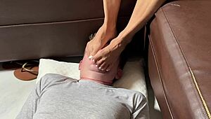 Submissive Husband Faces Asian Wife's Bare Feet in Domination Play