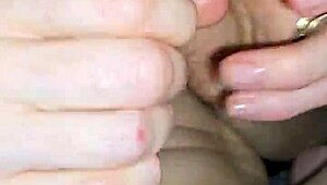 Glove-wearing milf milks cock with wet pierced nipples