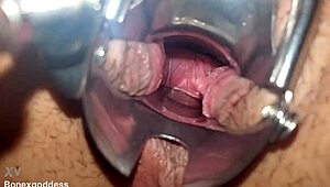 Close-up speculum stretches pink pussy walls wide open
