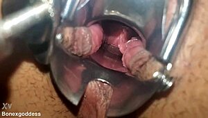 Close-up speculum stretches pink pussy walls wide open