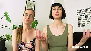 Two sexy German brunettes suck tits and kiss passionately in public hallway