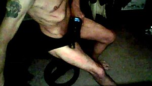 Skinny old woman applies percussion massager to thigh in underwear on stool