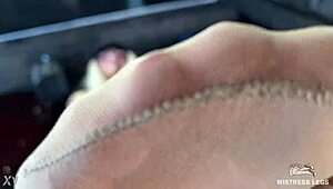 Mistress's nyloned toes tease seductively close-up on desk