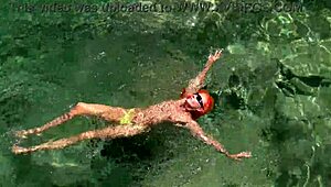 yellow trunks hug her curves against blue waves flashing wet shaved pussy outdoors