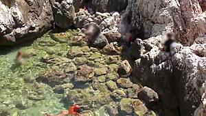 yellow trunks hug her curves against blue waves flashing wet shaved pussy outdoors