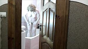 sexy blonde strips naked in bathroom as roommate jerks off watching her wet folds