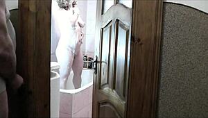 sexy blonde strips naked in bathroom as roommate jerks off watching her wet folds