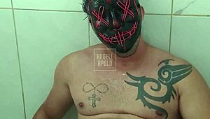 a masked tattooed man takes a shower alone and enjoys playing with his toy until he cums